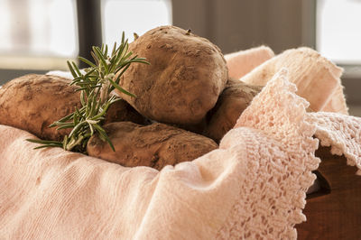 Potatoes with rosemary over fabric in basket