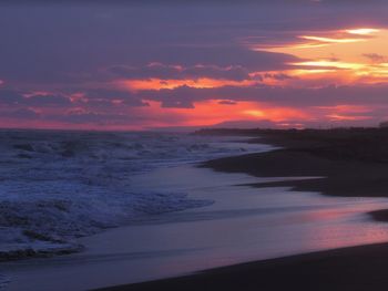 Scenic view of sea against dramatic sky during sunset