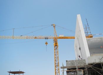 Low angle view of crane against clear sky