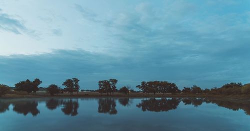 Reflection of trees in lake against sky