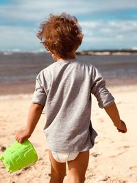 Rear view of boy standing on beach