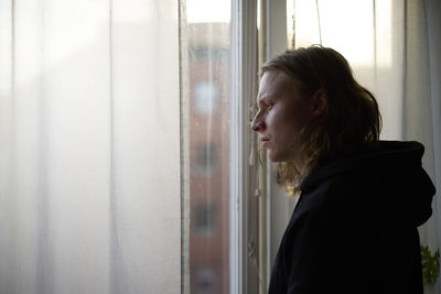 View of woman looking through window