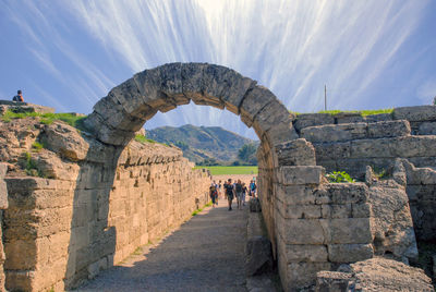 People on stone structure against sky