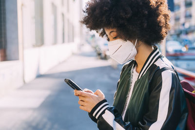 Low angle view of young woman using mobile phone