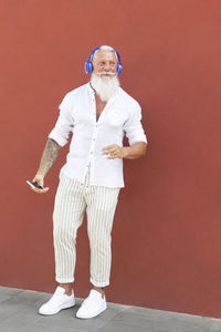 Portrait of man standing against red wall