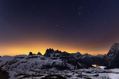 Scenic view of snowcapped mountains against sky at night