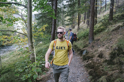 Full length portrait of young man standing in forest