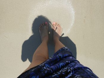 Low section of woman standing on beach