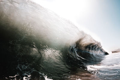 Waves splashing in sea against sky