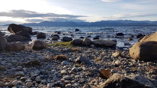 Rocks on beach against sky