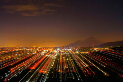 Light trails on road against sky at night