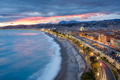 Panoramic view of city by sea against sky during sunset