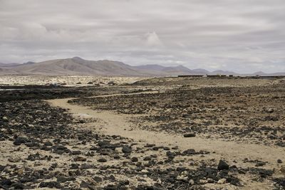 Scenic view of land and mountains against sky