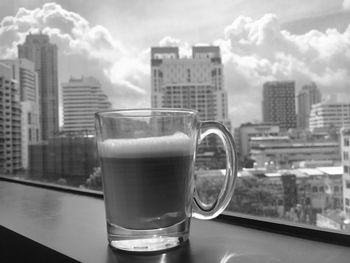 Close-up of drink in glass on window sill