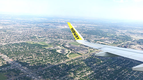 High angle view of airplane flying over cityscape