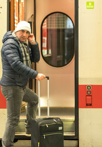 Portrait of man with luggage entering in train