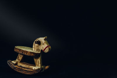 Close-up of rocking horse against black background