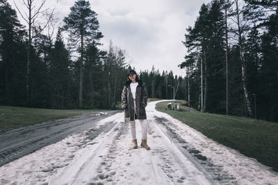 Full length of woman standing on snow covered land