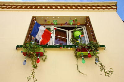 Low angle view of flags hanging on wall of building