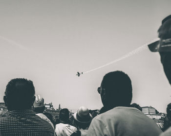 Rear view of people flying against sky