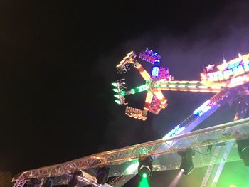 Low angle view of illuminated ferris wheel at night