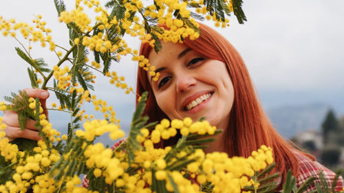 Young girl celebrates women's day with yellow mimosa flowers in hand