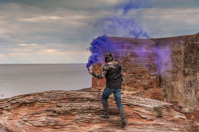 Full length rear view of man standing against sky