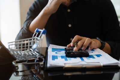 Midsection of man using calculator