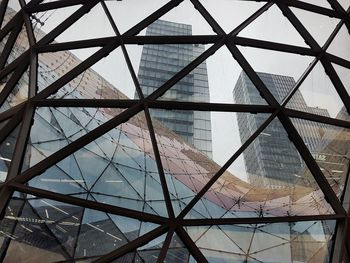 Low angle view of glass building against sky