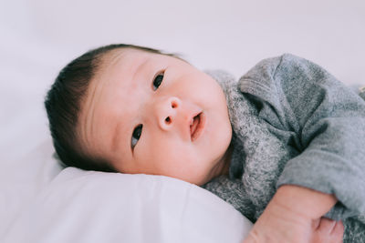 Portrait of cute baby lying on bed