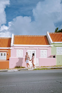 Woman by road against buildings in city