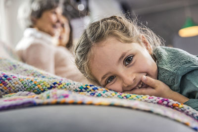 Portrait of cute girl lying on bed at home