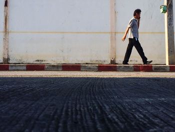 Man talking on mobile phone while walking on sidewalk