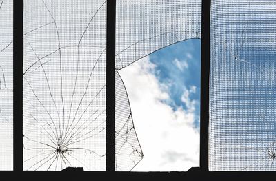 Low angle view of silhouette bridge by building against sky