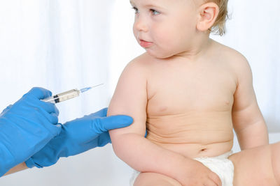 Doctor vaccinating baby in clinic. little newborn baby get an injection. vaccine for infant child.