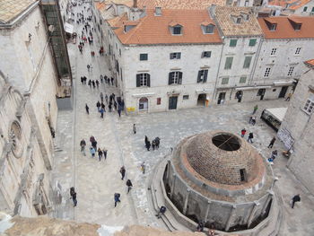 High angle view of people walking on road along buildings