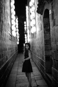 Full length portrait of woman standing against building