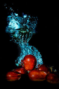 Close-up of apples in water against black background