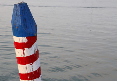 Colored pole called bricola in italian language to moor the boat near venice