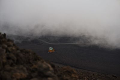 Scenic view of landscape against sky during foggy weather on top of etna volcano