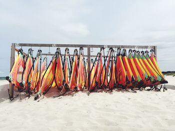 Multi colored umbrellas hanging on beach against sky