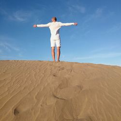 Woman standing on sand dune in desert