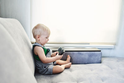 Side view of boy sitting at home