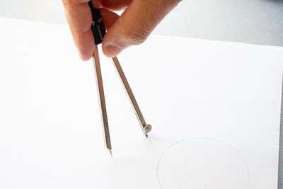 Midsection of person holding paper against white background