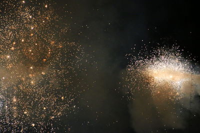 Low angle view of firework display at night