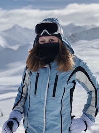 Portrait of woman standing on snow covered mountain