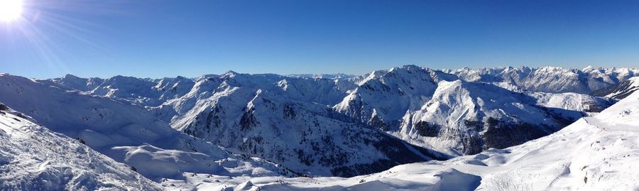 Scenic view of snowcapped mountains against clear blue sky