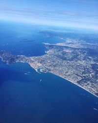 Aerial view of city by sea against sky