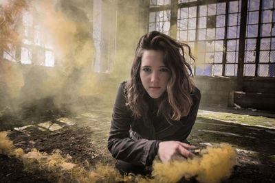 Portrait of young woman with distress flare in abandoned room