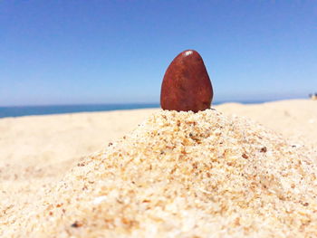 Close-up of stones on beach against clear sky